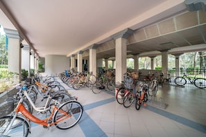 Ein überdachter Fahrradparkbereich mit mehreren Fahrrädern und Körben.