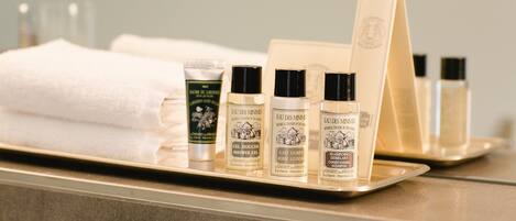 A tray with toiletries including shower gel, body lotion, and shampoo.
