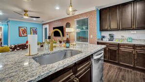 A modern kitchen with granite countertops, stainless steel appliances, and dark wooden cabinets. - Luxury Island Home – Pool Oasis, Near Downtown! (Savannah)