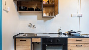 A kitchen with a black countertop, wooden cabinets, a built-in oven, and a sink.
