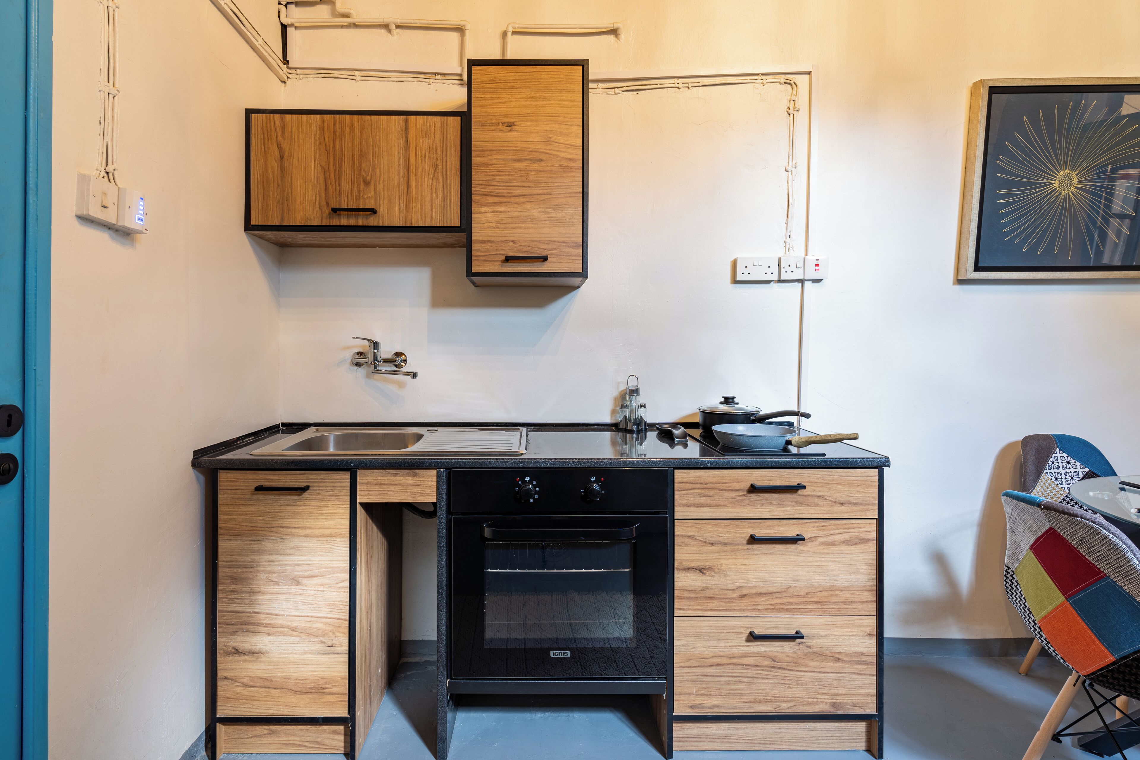 A compact kitchen with wooden cabinets, a built-in oven, and a sink.