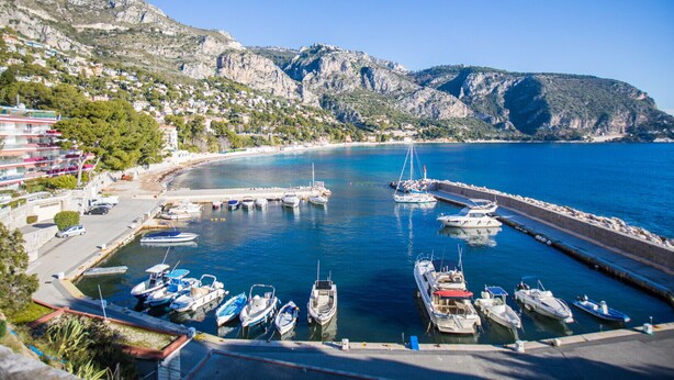 A marina with boats docked, a coastal town with buildings, and mountains in the background. - LA SOLEILLADE VI4451 By Riviera Holiday Homes (Eze)