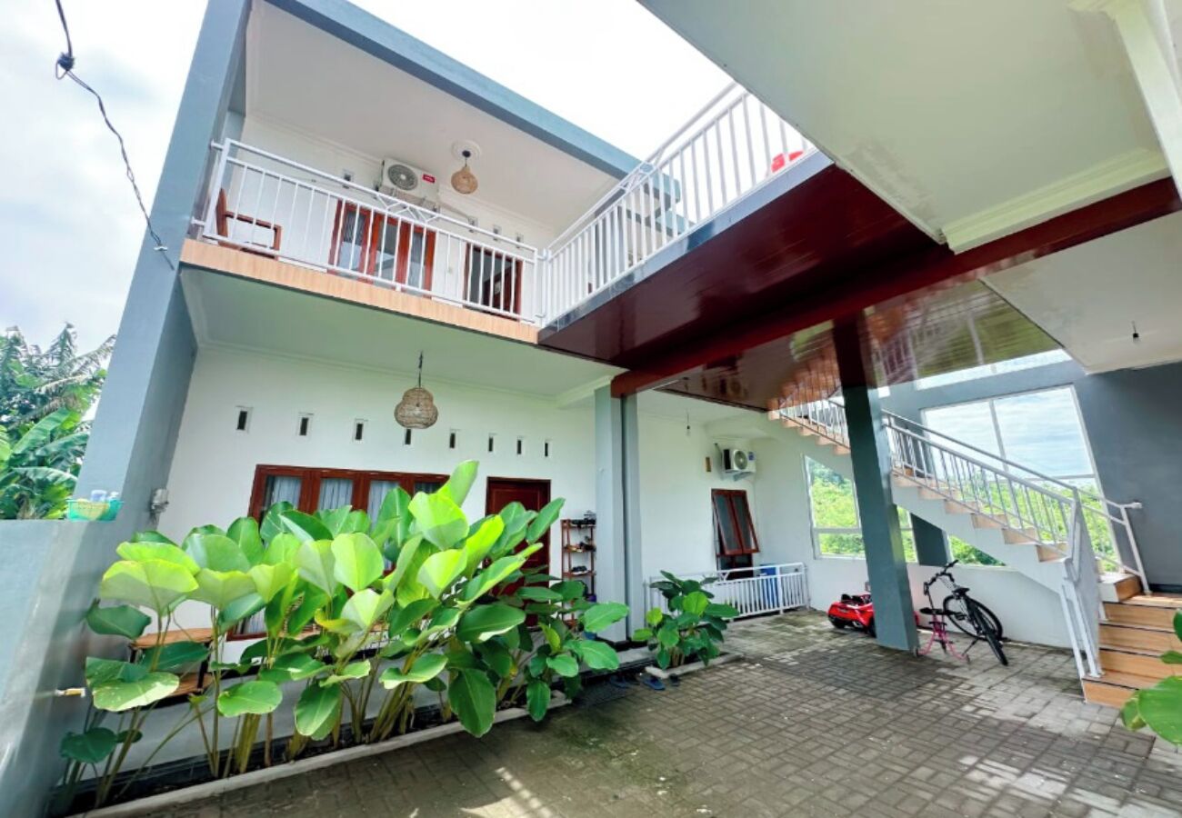 A two-story house with a balcony, a staircase, and a bicycle.
