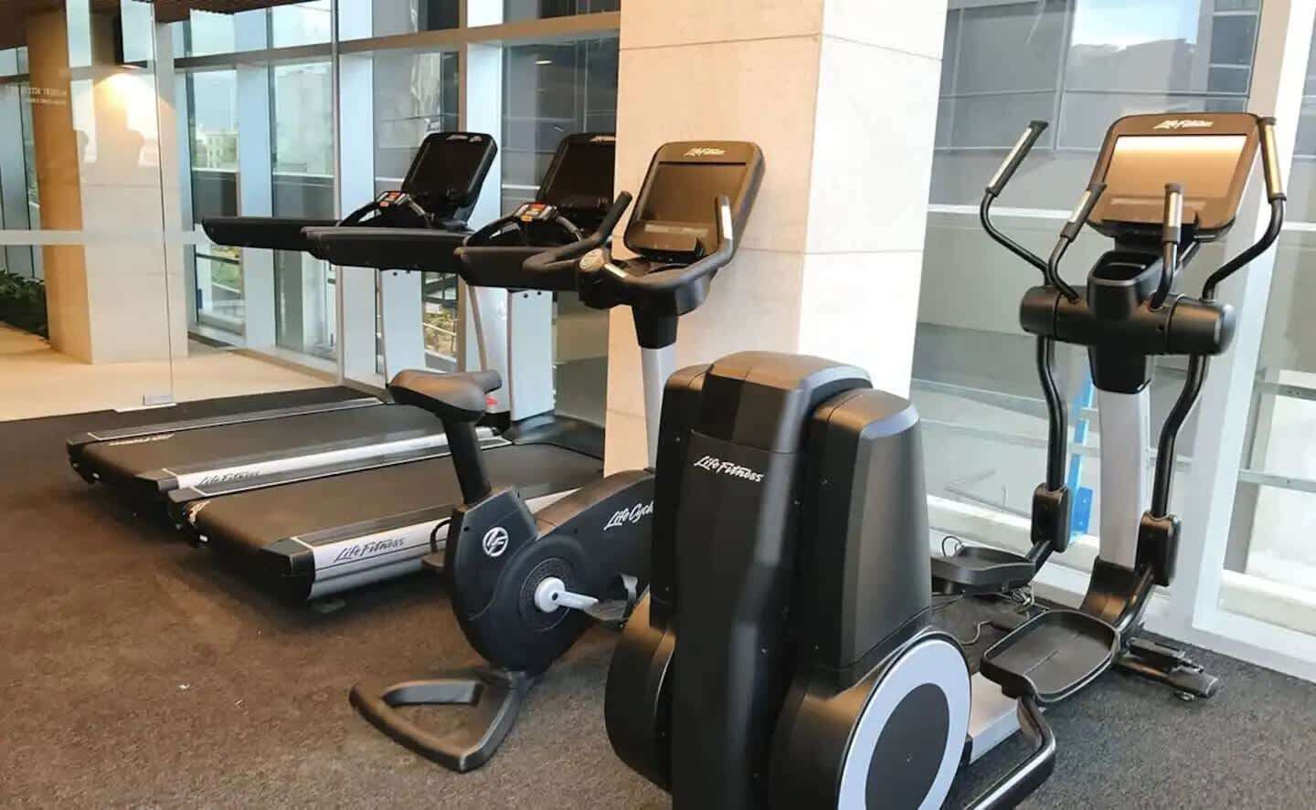 A gym with stationary bikes, treadmills, and an elliptical machine.