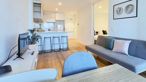 A modern apartment with a kitchen, a dining area, a living room, and a sofa.