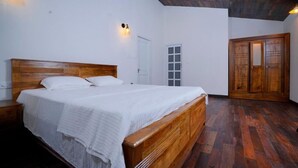 Ein Schlafzimmer mit einem hölzernen Bett, weißen Wänden und einem Holzschrank.