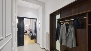 A hallway with a coat rack, a radiator, and a door leading to a room. - The Athenian Chic & Elegant Apartments in Kolonaki (Athens)