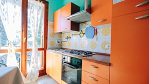 Una cocina con armarios naranjas, una estufa a gas y un horno empotrado.