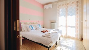 Una cama bien hecha con almohadas, una bandeja de croissants y toallas dobladas.