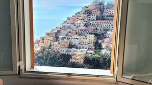 A window with a view of a hillside town. - Elle, a stone's throw from the Sea (Positano)