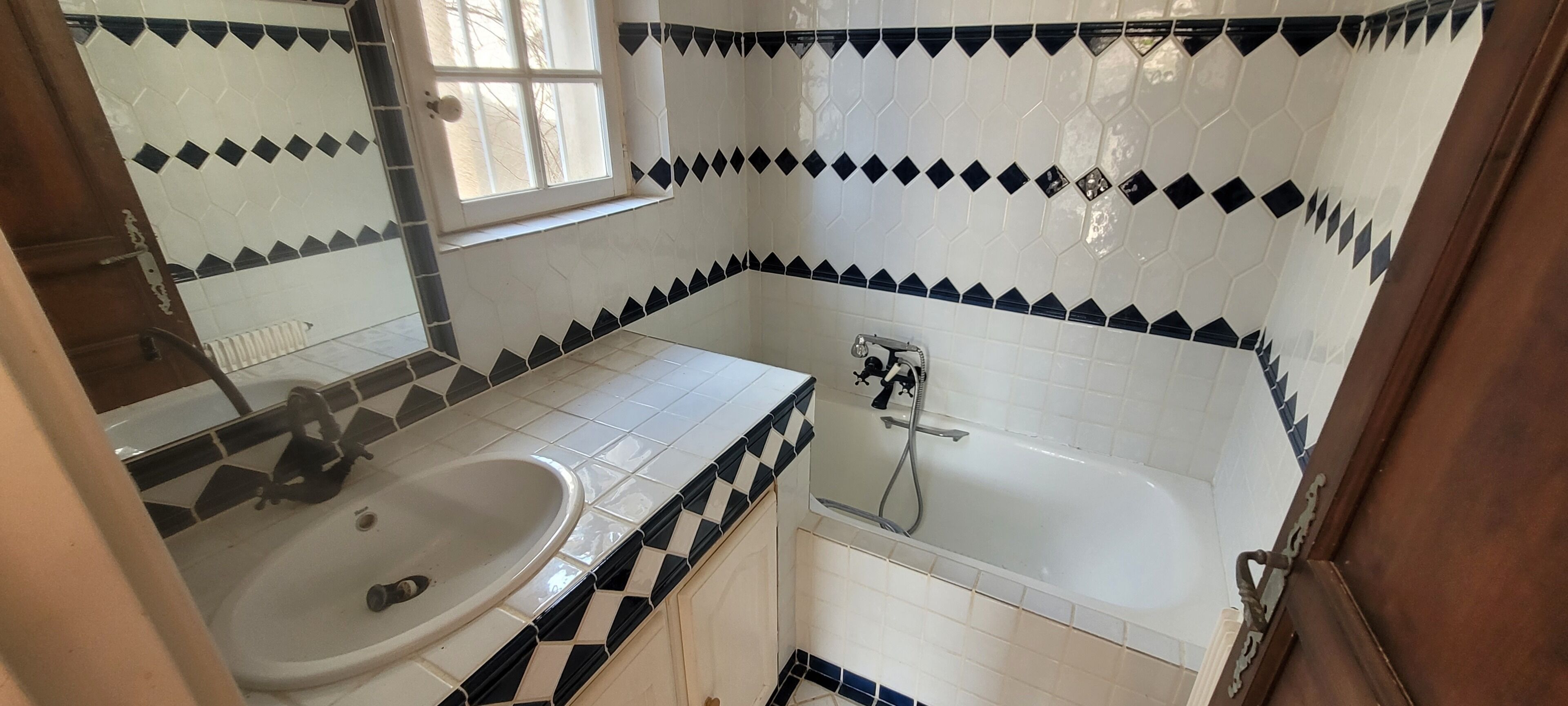 Ein Badezimmer mit Waschbecken, Spiegel und Badewanne.