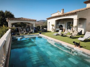 A swimming pool with lounge chairs and a patio area.