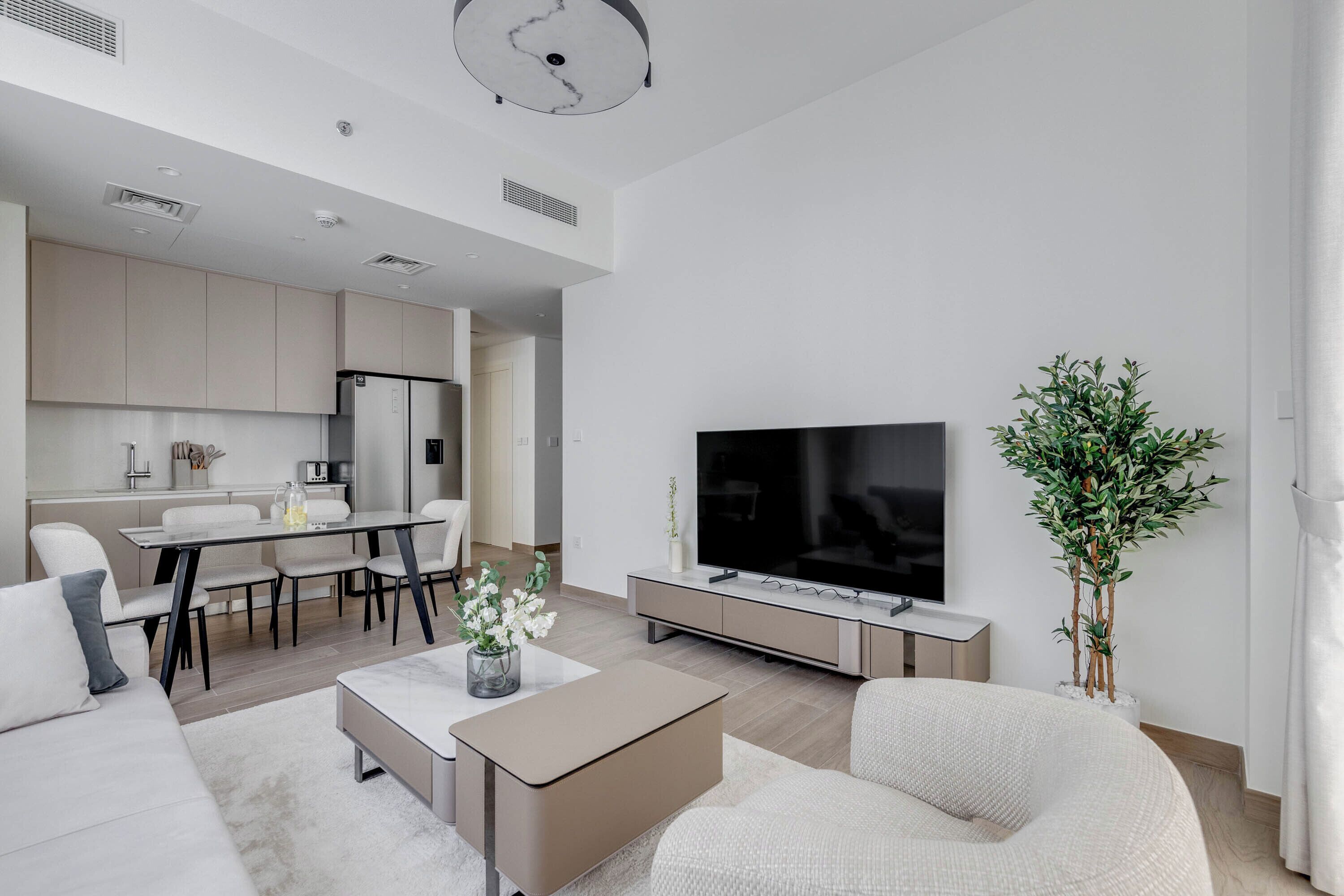 Ein modernes Wohnzimmer mit Flachbildfernseher, Essbereich und Küche.