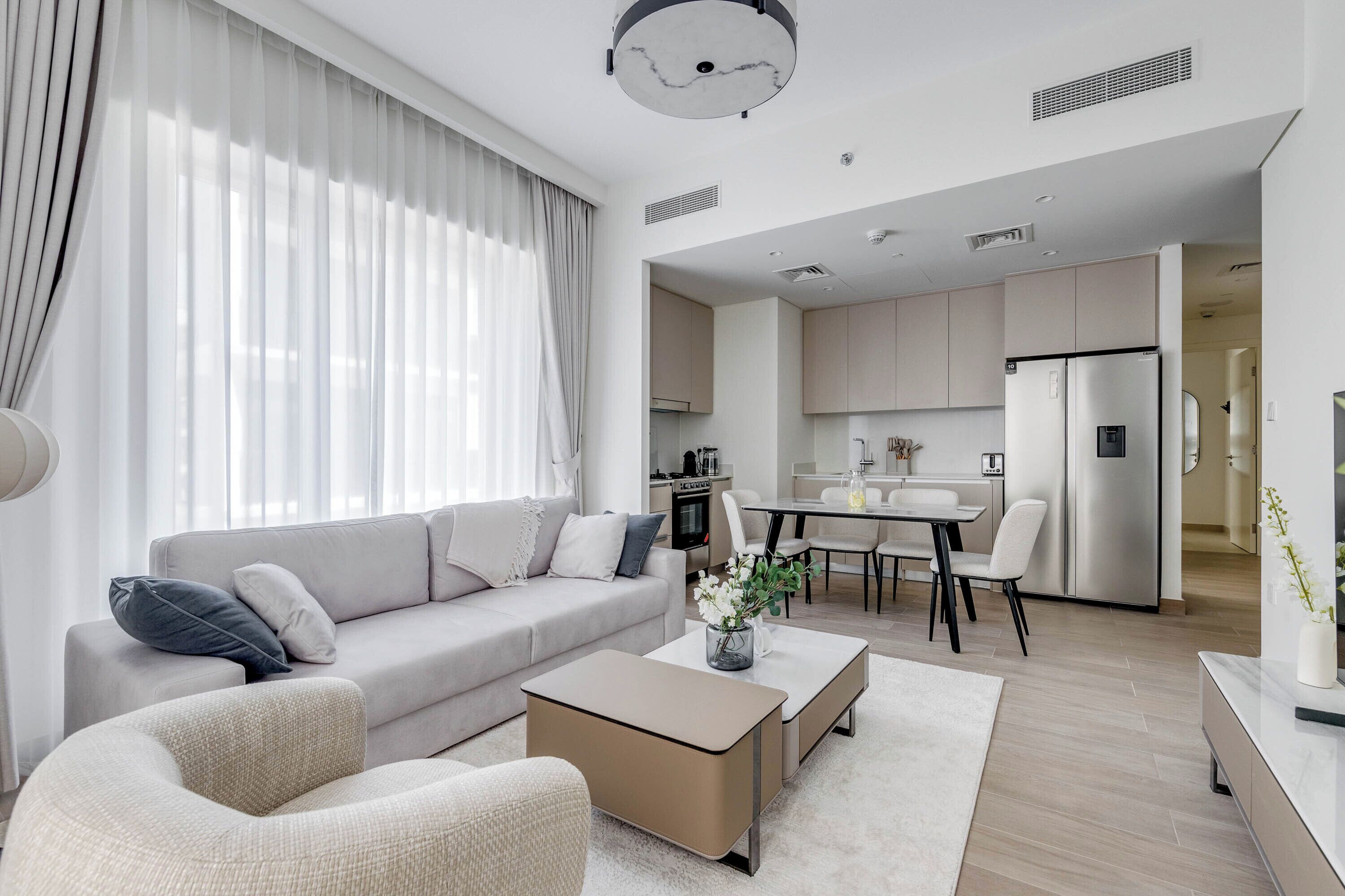 A modern living room with a sofa, coffee table, and dining area.