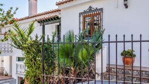 A white building with a tiled roof, a metal gate, and a potted plant. - Retreat with sea views & private heated pool! (Almuñecar)