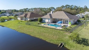 A residential area with houses, a swimming pool, and a body of water. - Peacock Shores | Team Joseph Ellen (Jacksonville)