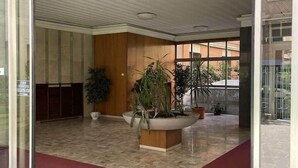 A modern lobby with a tiled floor, a red carpet, and several potted plants. - Sandrine - your comfy stay (Bologna)
