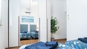 A bedroom with a bed, a mirror, a potted plant, and a wardrobe. - Sandrine - your comfy stay (Bologna)