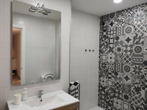 Secador de cabelo, toalhas de banho, shampoo, papel higiênico