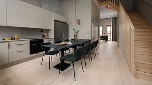 Une cuisine moderne avec un coin repas, un escalier et une vue sur l’extérieur.