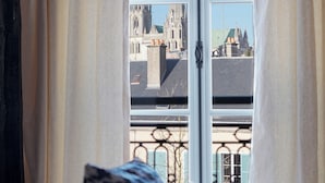 Een kamer met uitzicht op een kathedraal door een raam met gordijnen.