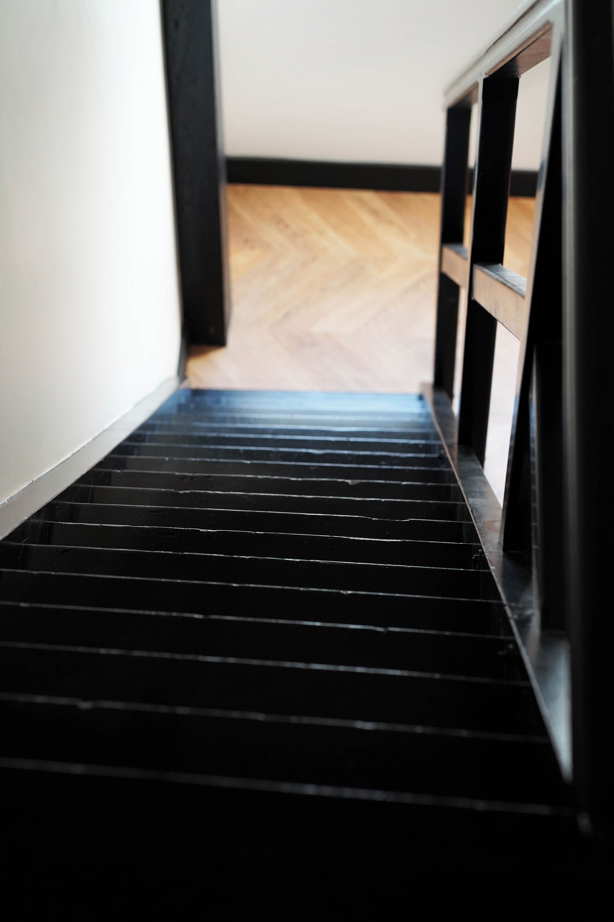 Una escalera de metal negro que conduce a un suelo de madera.
