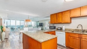A modern kitchen with granite countertops, wooden cabinets, and a built-in microwave. - Crab Feasts, Bay Breezes & Boardwalk Nights | Summer Starts Here (Ocean City)