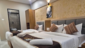 Camera d'albergo con due letti, un armadio in legno, pavimento in marmo e un quadro appeso al muro.