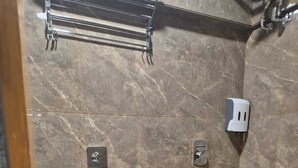 Un bagno moderno con parete in marmo, un water, un asciugamani ad aria e un porta asciugamani.