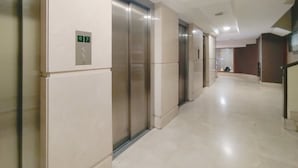 Un couloir doté d’ascenseurs et d’un écran numérique indiquant le numéro de l’étage.