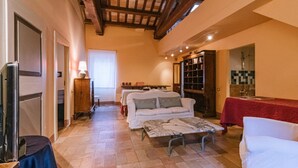A cozy living room with a sofa, a coffee table, and a fireplace. - Much loved by many: FIENILE, in the historic center, 7 km from the sea (Fermo)