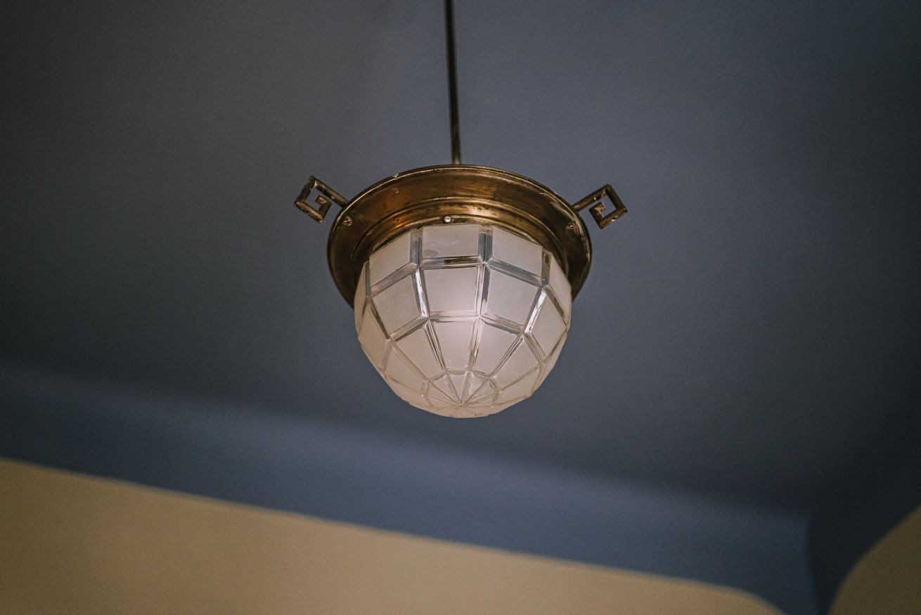 A hanging light fixture with a geometric glass design and a metal frame.