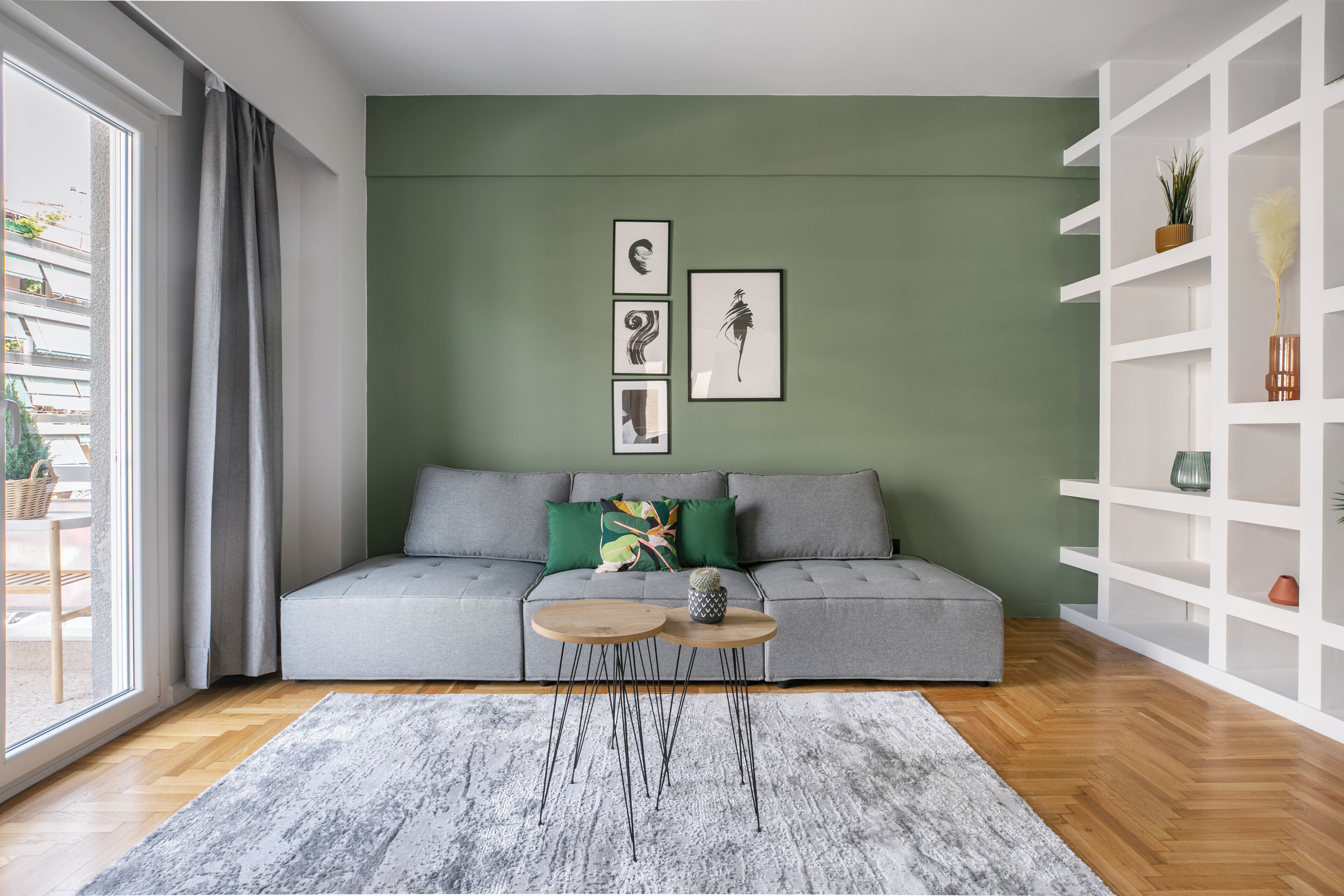 Una sala moderna con un sofá gris, una mesa de centro y una alfombra gris.