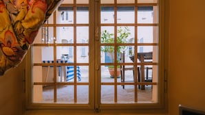 A window with a grid pattern, a potted plant, and a table outside. - In the city center, 7 km from the sea (Fermo)