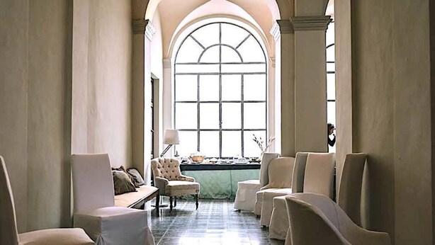 A spacious room with a large arched window, several upholstered chairs, a small table, and a lamp. - PALAZZO to live in, historic center, gardens terraces, 7 km from the sea (Fermo)