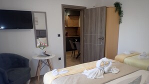 A hotel room with a bed, a desk, a chair, and a TV.