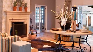 Ein Wohnzimmer mit Kamin, einem runden Tisch mit Blumenvase und einem Cowhide-Teppich.