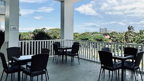 Une terrasse extérieure avec une balustrade blanche, une table et des chaises.