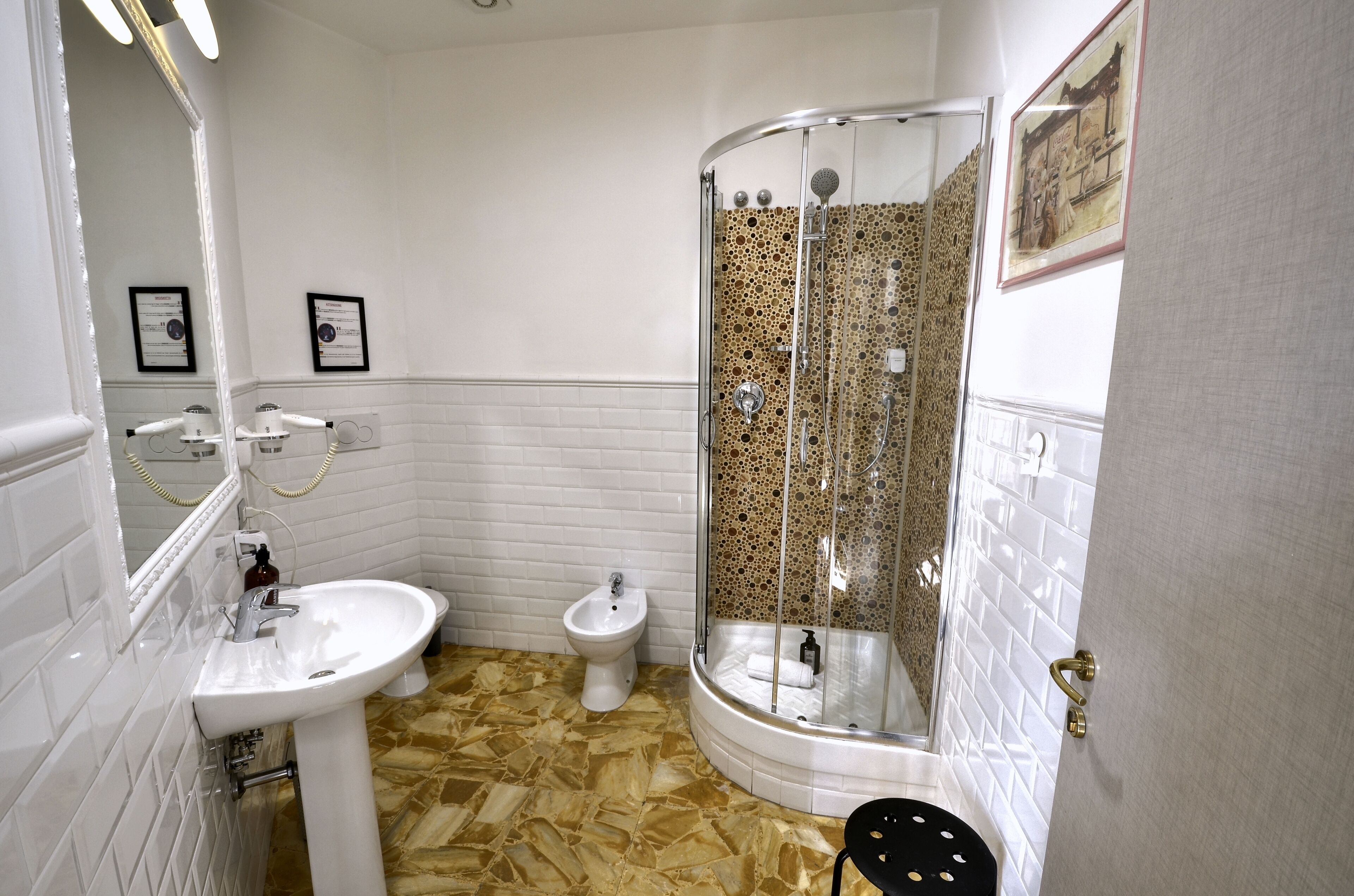 A bathroom with a white sink, bidet, and glass-enclosed shower.