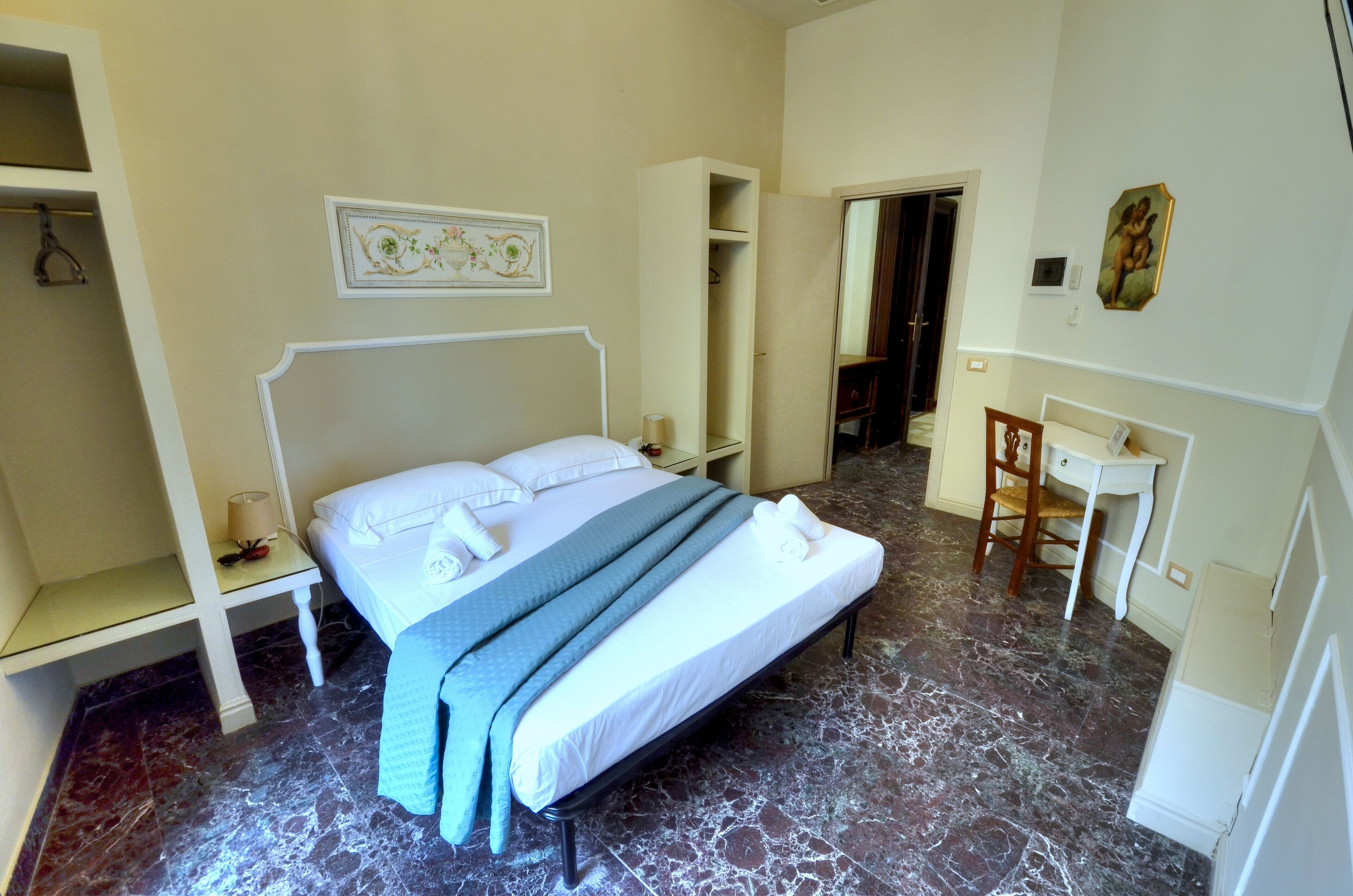 Une chambre d’hôtel avec un lit, un bureau et une chaise.