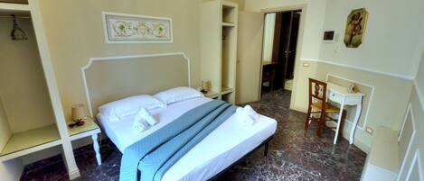 Une chambre d’hôtel avec un lit, un bureau et une chaise.
