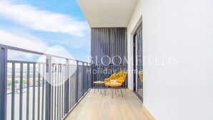 Ein Balkon mit Blick auf einen Fluss, einem Stuhl und einem Tisch.