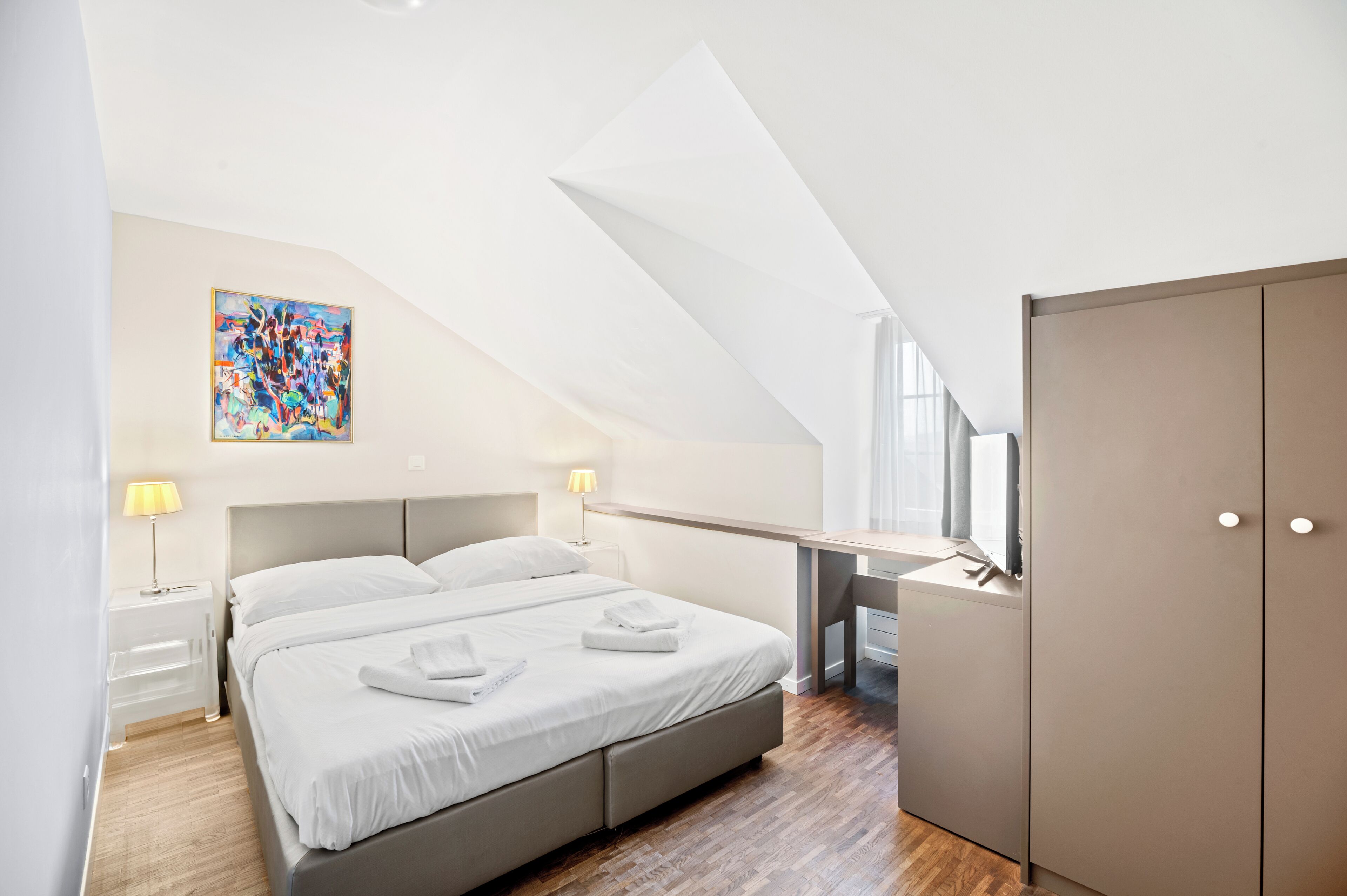 Una camera da letto moderna con un letto grande, una scrivania e un armadio.
