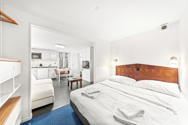 Une chambre d’hôtel équipée d’un lit, d’un bureau, d’une chaise et d’une kitchenette.