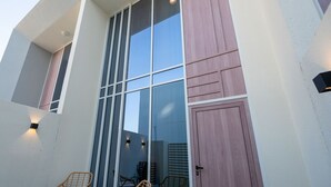 A modern building with large windows and a flat roof. - Bloomfields Premium 1BR Duplex in Rukan (Dubai)