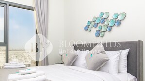 A hotel room with a bed, pillows, a nightstand, and a wall decoration. - Bloomfields Stylish 2Br in Rukan (Dubai)