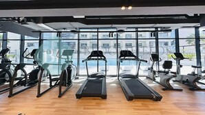 Un gimnasio con cintas de correr, elípticas y bicicletas estáticas.