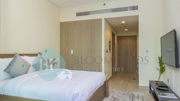 Un dormitorio moderno con una cama de madera, un televisor de pantalla plana y un vestidor.