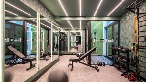A modern gym with mirrored walls, exercise equipment, and a patterned carpet. - The Pal Living in a Concept (Heraklion)