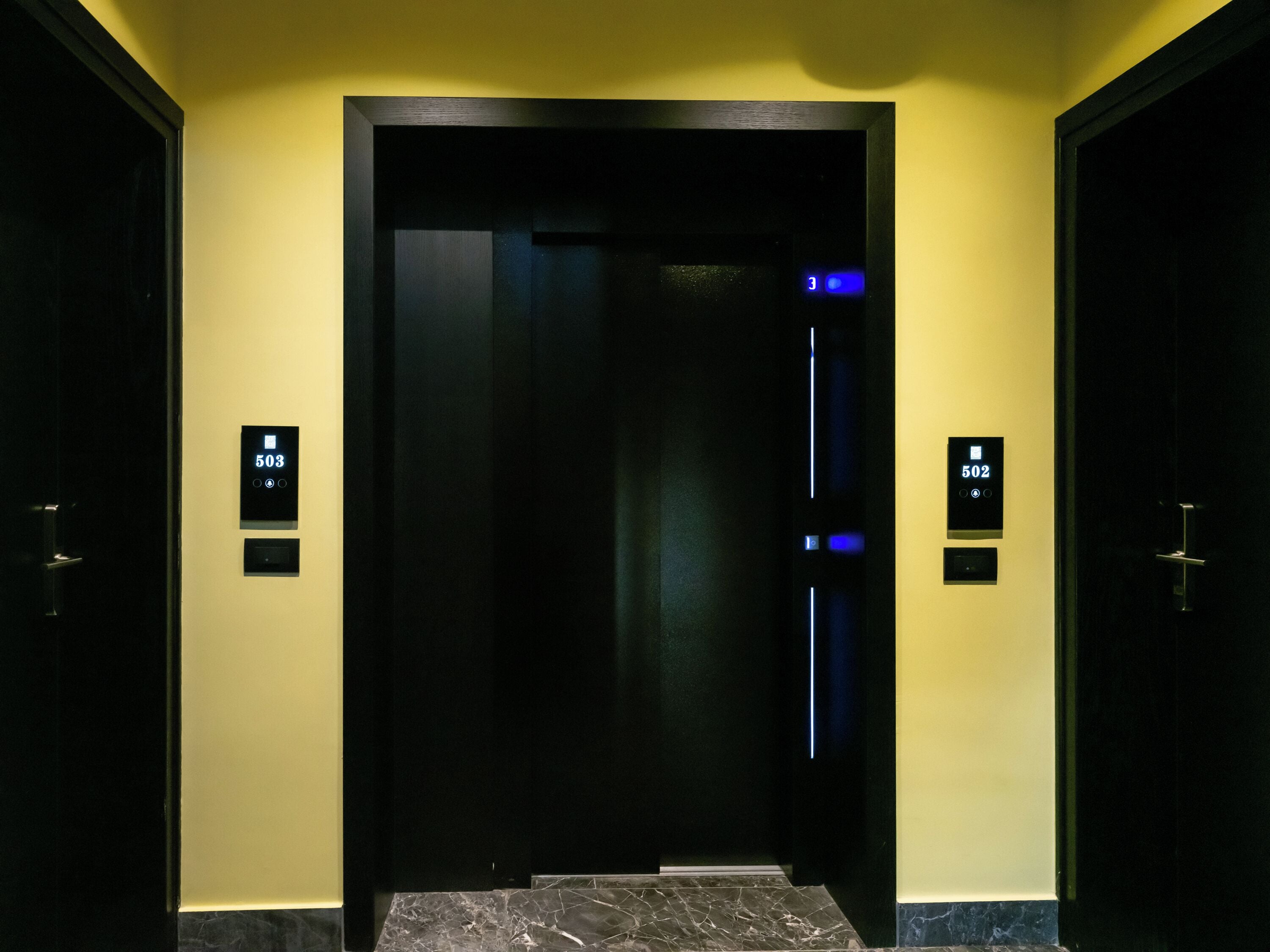 An elevator with digital floor indicators showing 503 and 502.